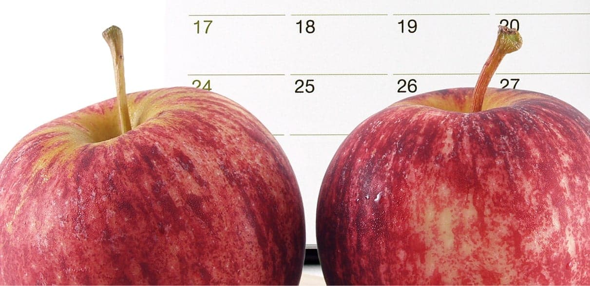Fresh apples beside a wall calendar