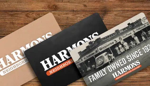 Three Harmons gift cards fanned out on a wooden table