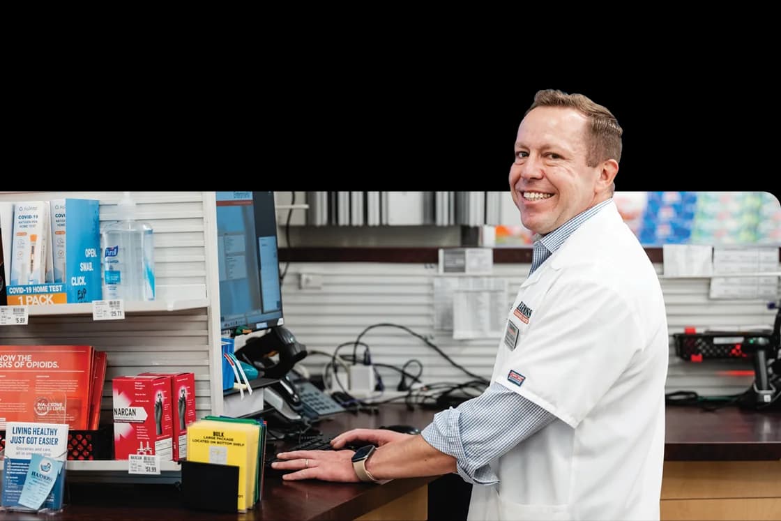 Harmons pharmacist smiling at the pharmacy computer