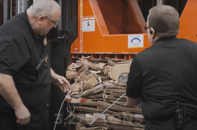 Two Harmons associates baling cardboard for recycling